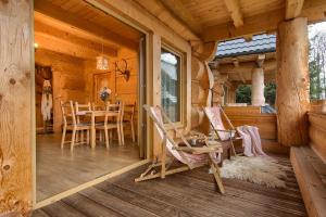 une véranda d'une cabane en rondins avec une table et des chaises dans l'établissement Domy Z Bali, à Zakopane