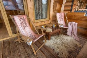 2 chaises et une table sur une terrasse couverte d'une cabine dans l'établissement Domy Z Bali, à Zakopane