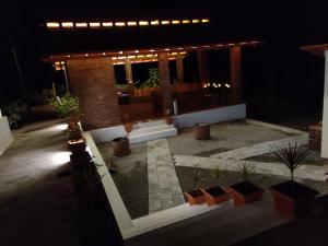 a house with a courtyard with potted plants at night at The Brown and Brew Homestay in Chikmagalūr