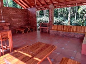 an outdoor patio with a wooden table and benches at The Brown and Brew Homestay in Chikmagalūr