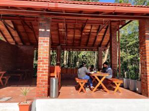 two people sitting at a table on a patio at The Brown and Brew Homestay in Chikmagalūr