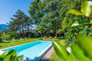 un'immagine di una piscina in un cortile alberato di Überbacherhof a Termeno