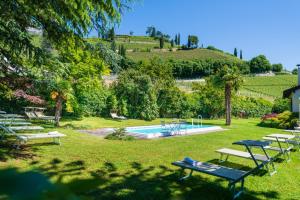 un gruppo di tavoli da picnic sull'erba vicino alla piscina di Überbacherhof a Termeno