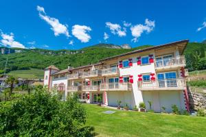 un grande edificio bianco con balconi su un prato di Überbacherhof a Termeno