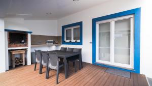 une salle à manger avec une table et des chaises noires dans l'établissement Quinta Rico - House II, à Praia da Vitória