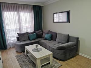 uma sala de estar com um sofá e uma mesa de centro em Apartman DalMe em Novi Pazar