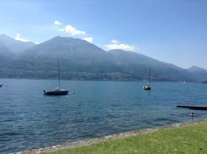 due barche su un lago con montagne sullo sfondo di Osteria La Riva a Locarno