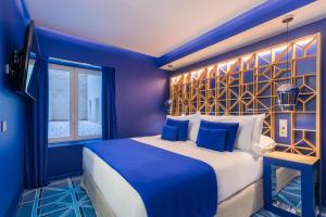 a blue bedroom with a large bed and a window at Room Mate Macarena – Gran Vía in Madrid