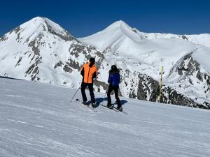 two people on skis on a snow covered mountain at Park Hotel Panorama in Bansko