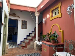 uma casa com uma parede vermelha com uma escada em Casa Boutique Eros em Carmona