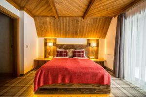 - une chambre avec un grand lit et une couverture rouge dans l'établissement Gościniec Kuźnice, à Zakopane