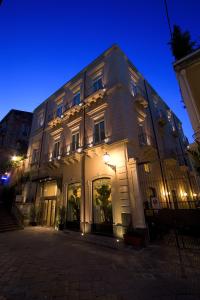 un gran edificio blanco con luces encendidas por la noche en Il Principe Hotel Catania, en Catania