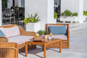 2 rieten stoelen en een salontafel op een patio bij Amalia Hotel Olympia in Olympia