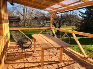 un banco de madera y 2 sillas en el patio en Rīga Mangalsala Cottage with sauna, en Riga