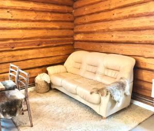 Sofá blanco en una habitación con pared de madera en Rīga Mangalsala Cottage with sauna, en Riga