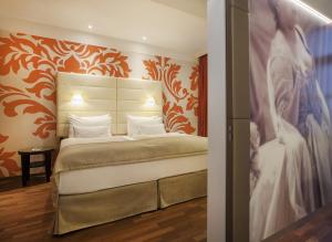 a bedroom with a bed and a painting of a bride at Boutique Hotel Das Tigra in Vienna