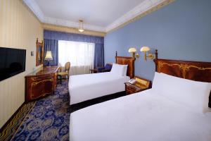 a hotel room with two beds and a television at Hotel Lisboa in Macau