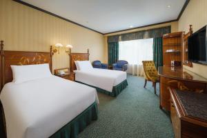 a hotel room with two beds and a television at Hotel Lisboa in Macau