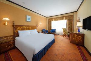 a hotel room with a large bed and a television at Hotel Lisboa in Macau