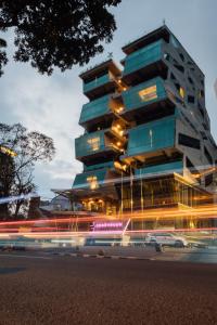 un grand bâtiment avec des panneaux lumineux devant lui dans l'établissement Janevalla Bandung, à Bandung