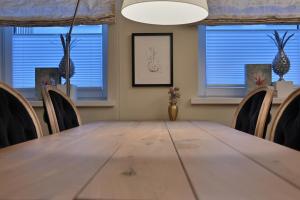 una mesa y sillas en una habitación con ventanas en Ferienwohnung PRACHTSTÜCK, en Flensburg