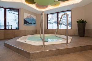 une baignoire jacuzzi dans une chambre avec fenêtres dans l'établissement Hotel Caprice - Grindelwald, à Grindelwald