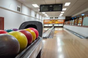 uma pista de bowling com pinos e maçãs nas pistas em Hotel Barátság em Hajdúszoboszló