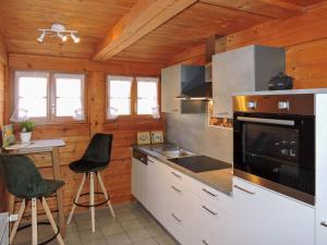 La cuisine est équipée de placards blancs et d'un four avec plaques de cuisson. dans l'établissement Apartment Blank by Interhome, à Titisee-Neustadt