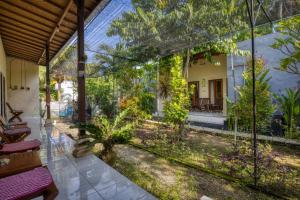 uma vista para um jardim a partir do interior de uma casa em Ari La Casa em Nusa Penida