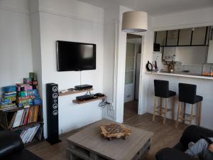 uma sala de estar com uma televisão na parede em Bel appartement em Boulogne-sur-Mer