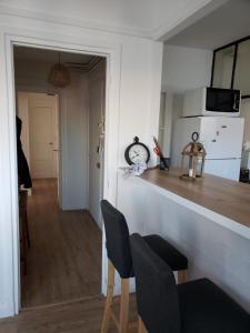 uma cozinha com um balcão com duas cadeiras e uma mesa em Bel appartement em Boulogne-sur-Mer