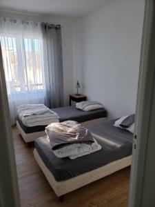 um quarto com duas camas e uma janela em Bel appartement em Boulogne-sur-Mer