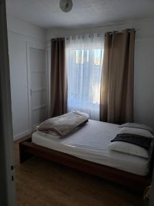 um quarto com uma cama grande e uma janela em Bel appartement em Boulogne-sur-Mer