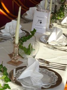 - une table avec des assiettes, des serviettes et des bougies dans l'établissement Landhotel Kastanienallee Putbus, à Putbus