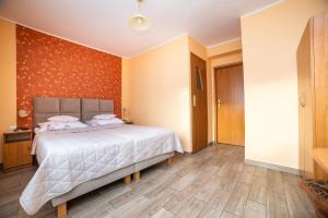 a bedroom with a large bed with orange walls at Dom Wczasowy Grażyna in Władysławowo