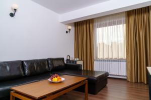 sala de estar con sofá de cuero negro y mesa en Свети Никола, en Razlog