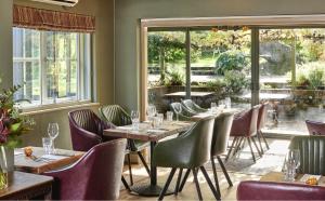 een restaurant met houten tafels, stoelen en ramen bij The Jolly Sportsman in Lewes