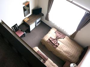 einen Blick über ein Zimmer mit einem Bett und einem Schreibtisch in der Unterkunft Petit Hotel Blaneneige in Nakafurano