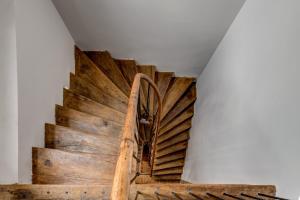 - un escalier en bois dans une chambre dotée d'un mur blanc dans l'établissement Upstairs Boutique, à Bucarest