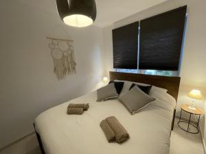 een slaapkamer met een groot wit bed met 2 kussens bij Le Relax by La Dame de Coeur - Logement zen urbain in Namen