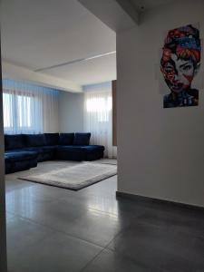 - un salon avec un canapé et un tableau mural dans l'établissement Gamma Apartmanok és Jakuzzi, à Miskolctapolca