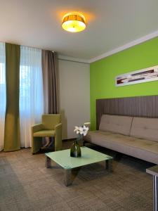 a living room with a couch and a table at Hotel Ambiente Walldorf in Walldorf