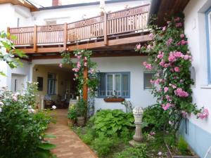 una casa con balcone e fiori nel cortile di Stieglerhof Apartments Dr Eitner GnbR Bernd und Edeltrud a Illmitz