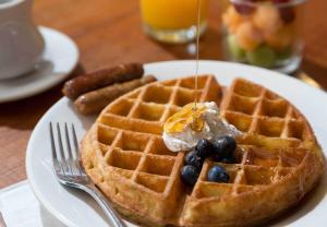 ein Teller Waffeln und Wurst auf dem Tisch in der Unterkunft Lord Camden Inn in Camden