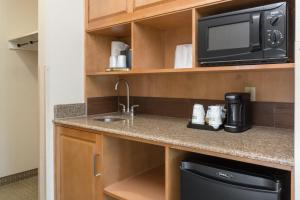 a kitchen with a sink and a microwave at Holiday Inn Express & Suites Santa Clara - Silicon Valley, an IHG Hotel in Santa Clara