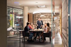 a group of people sitting at a table in a restaurant at GHV Hotel in Vicenza