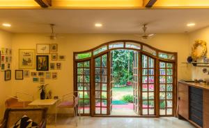 ein Wohnzimmer mit einer Tür zum Hof in der Unterkunft SaffronStays Birdsong, Madh - pet-friendly villa at Madh Island in Mumbai