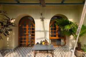 einem Tisch vor einem Gebäude mit zwei Türen in der Unterkunft SaffronStays Birdsong, Madh - pet-friendly villa at Madh Island in Mumbai