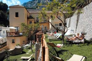 a view of a courtyard with chairs and a building at Loft Apartments by AMALFIVACATION in Amalfi