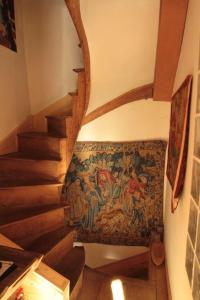 a hallway with a staircase with a tapestry on the wall at Golden Lion in Bouillon